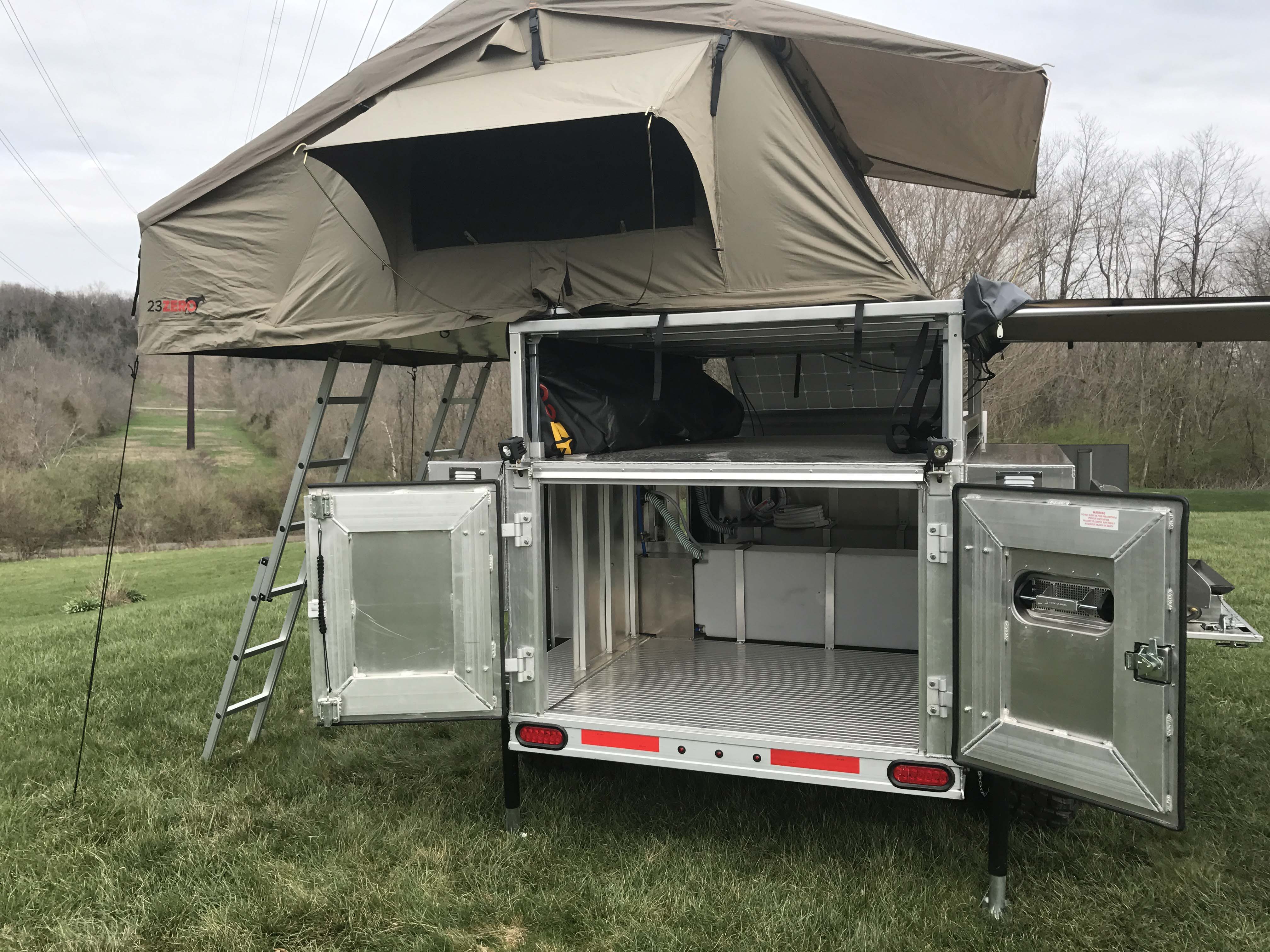 Utility trailer with roof top outlet tent